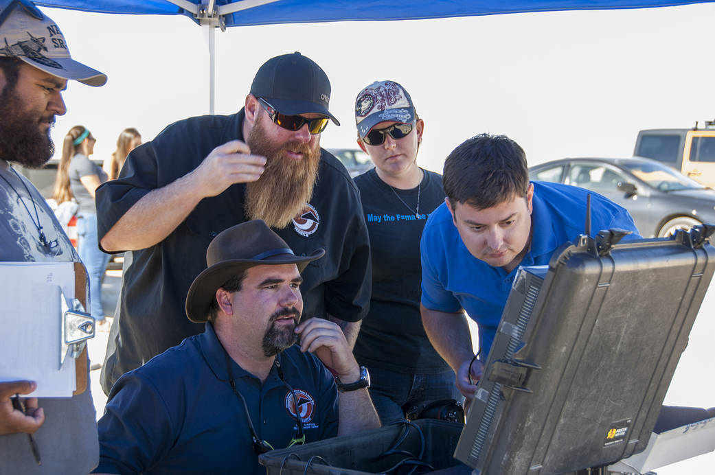 Jonathan Adams, from left, John Bodylski, Justin Hall, Caitlin Kennedy and Dave Berger watch a computer screen.