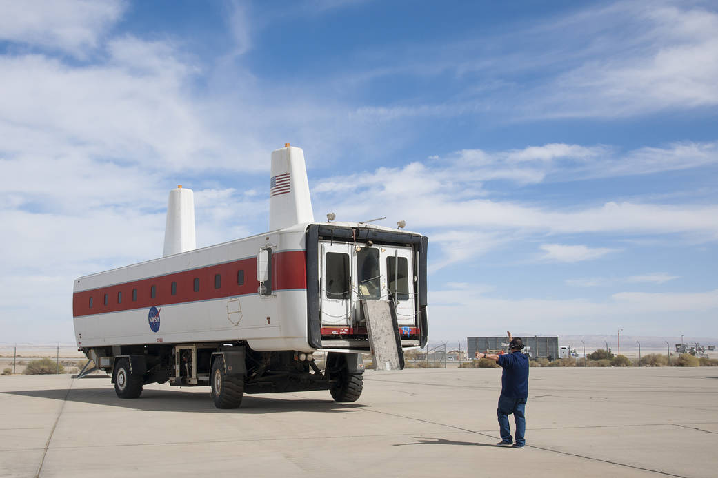 Workers drive the space shuttle Crew Transport Vehicle, or CTV, to the Edwards Air Force Base Flight Test Museum.