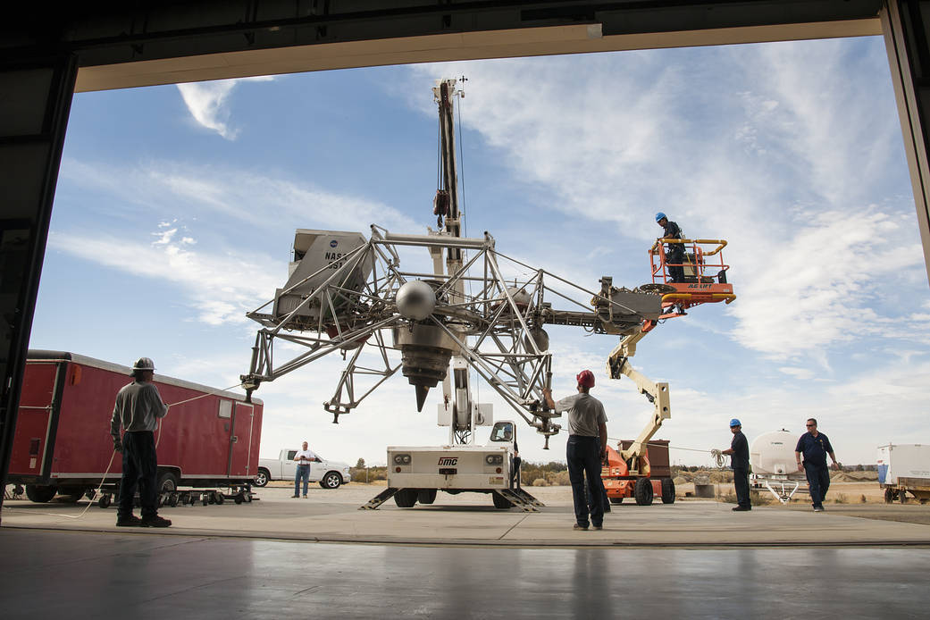 Workers move the Lunar Landing Research Vehicle, or LLRV, into the Edwards Air Force Base Flight Test Museum.