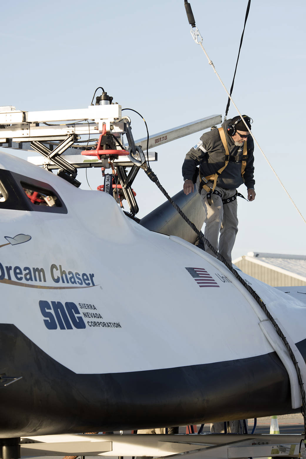 Sierra Nevada Corp’s Dream Chaser crew attached the wires that the helicopter would use to pick it up at AFRC.