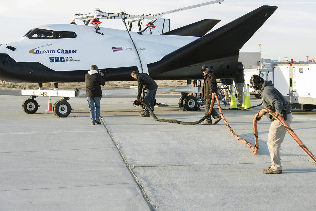 Sierra Nevada Corp’s Dream Chaser crew attached the wires that the helicopter would use to pick it up at AFRC.