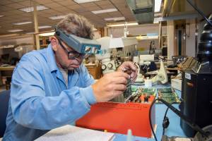 Randy Wagner prepares elements of the Orion Ascent Abort 2 crew module backup data acquisition system for thermal testing.