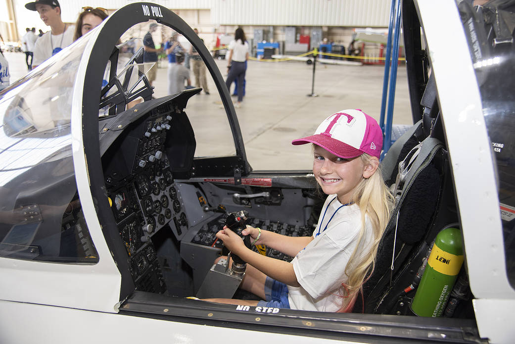 Rylee Ritter sits in a mockup of an F-15 cockpit.