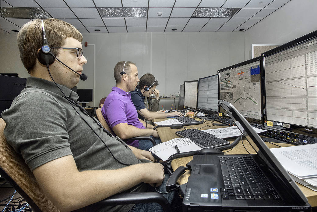 Jake Schaefer, left, looks over control information on a monitor in front of him for the X-56A before flight.