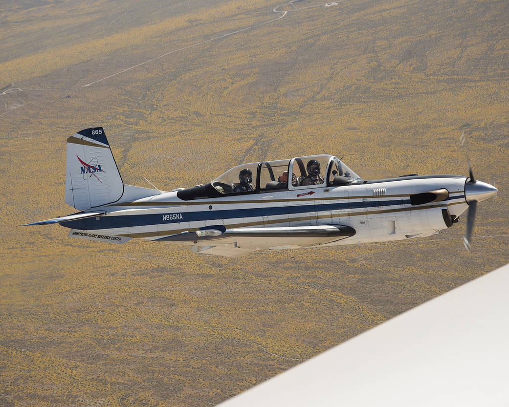 NASA’s T-34 aircraft flies over an abundance of yellow wildflowers as it heads toward Southern California’s Antelope Valley Popp