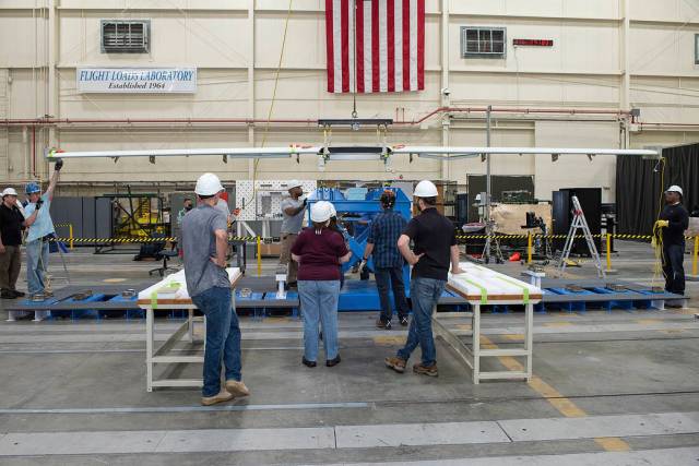Engineers and specialists prepare X-57s Mod III wing for testing in the Flight Loads Lab at AFRC.