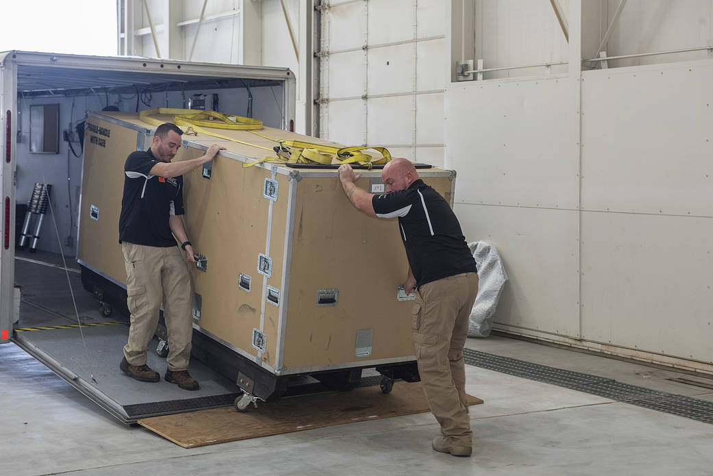 Navmar Applied Sciences Corporation personnel unload the crate containing the TigerShark.