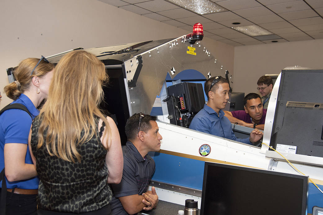 NASA's 2017 astronaut candidates practice flying in an X-59 QueSST simulator at AFRC.