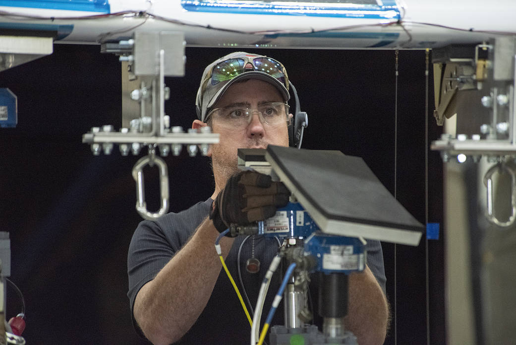 Ray Sadler adjusts hydraulic actuators with pads to the wing of the X-57 distributed electric aircraft wing.