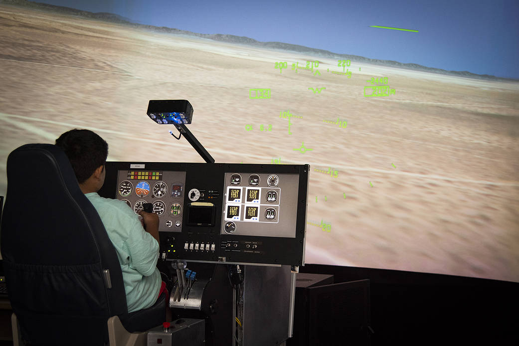 An elementary student flies the X-57 simulator at AFRC.