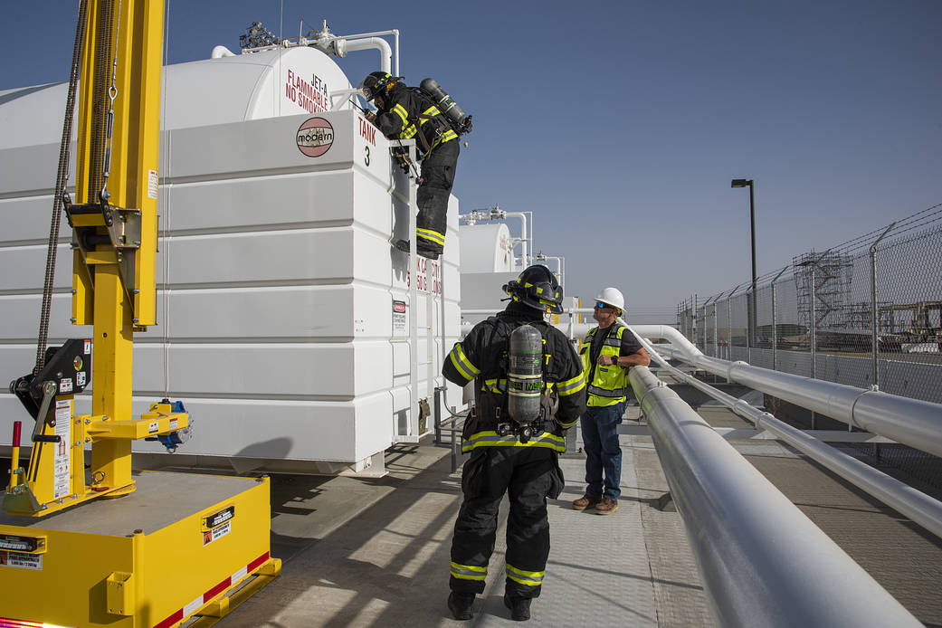 Air Force Plant 42 Fire Department responders Doug Mendez and Alfonzo Ortega test the air in a confined space with a gas meter.