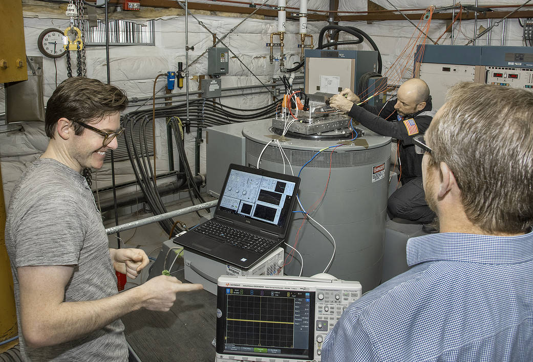 NASA engineer Jacob Terry, left, and Operations Manager Matthew Shemenski of Empirical Systems Aerospace (ESAero), right, prepare an X-57 cruise motor controller for vibration testing.