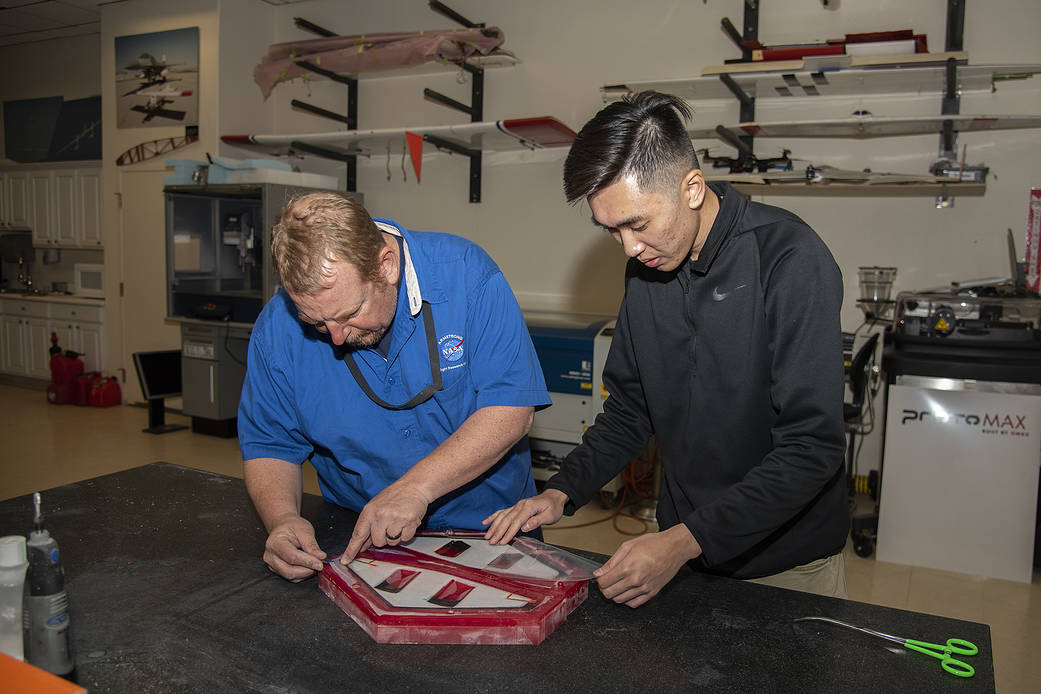 Nathan Sam and Robert “Red” Jensen lay material into a Prandtl-M aircraft mold.