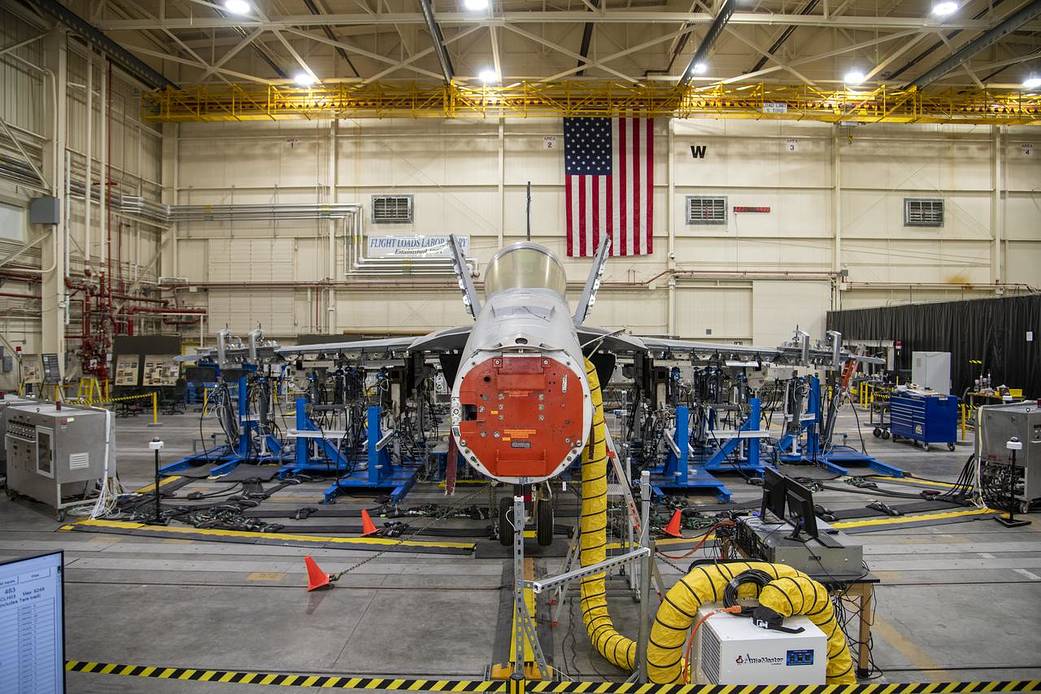 airplane being tested inside a hangar, front view, no nose on the aircraft.