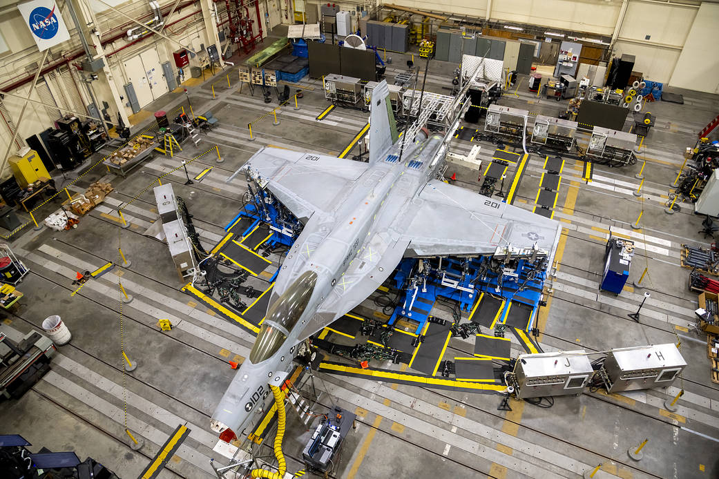 A top view shows the wing loading test configuration of a F/A-18E from the Naval Air Systems Command (NAVAIR) in Patuxent River, Maryland.