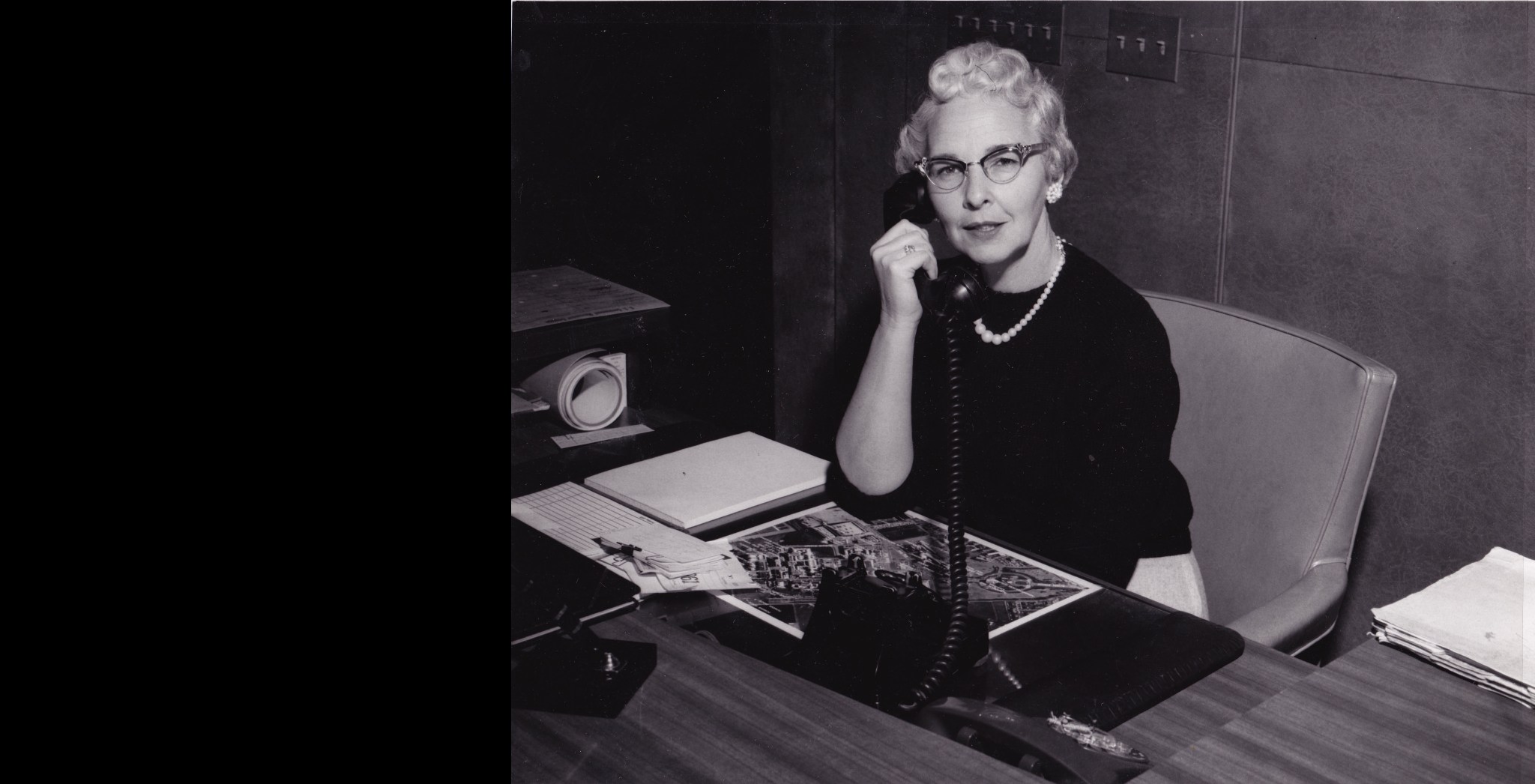 Black and white photograph of Ames Receptionist Beatrice Aikman on the telephone at her desk