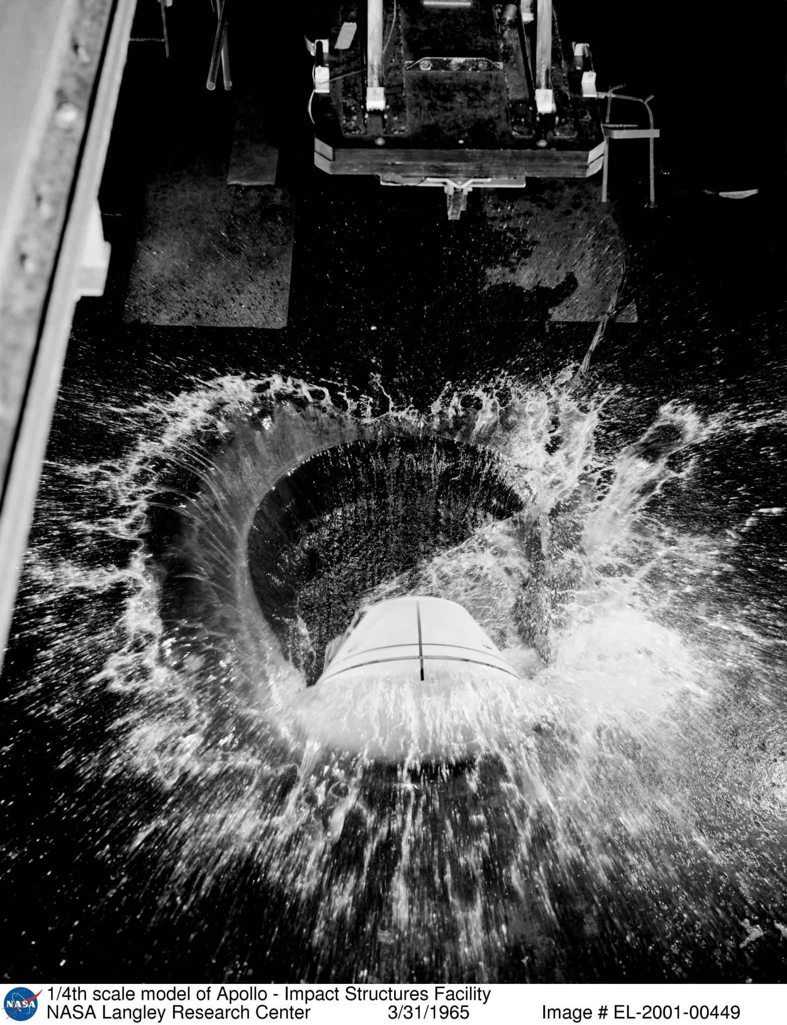 To determine water-landing characteristics of the Apollo capsule, a ¼ scale model, seen here during testing in in the Impacts Facility in 1965, was dropped from an overhead pendulum device.