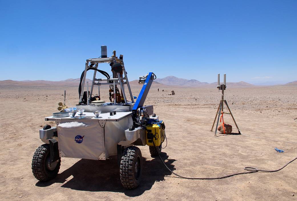 The ARADS rover is plugged in for a recharge during field tests in the Atacama Desert. To the right is a wifi antenna.