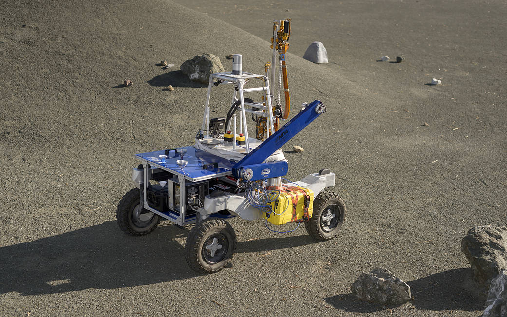 The ARADS rover sits on the Roverscape at NASA's Ames Research Center, with rocks and a slope nearby.