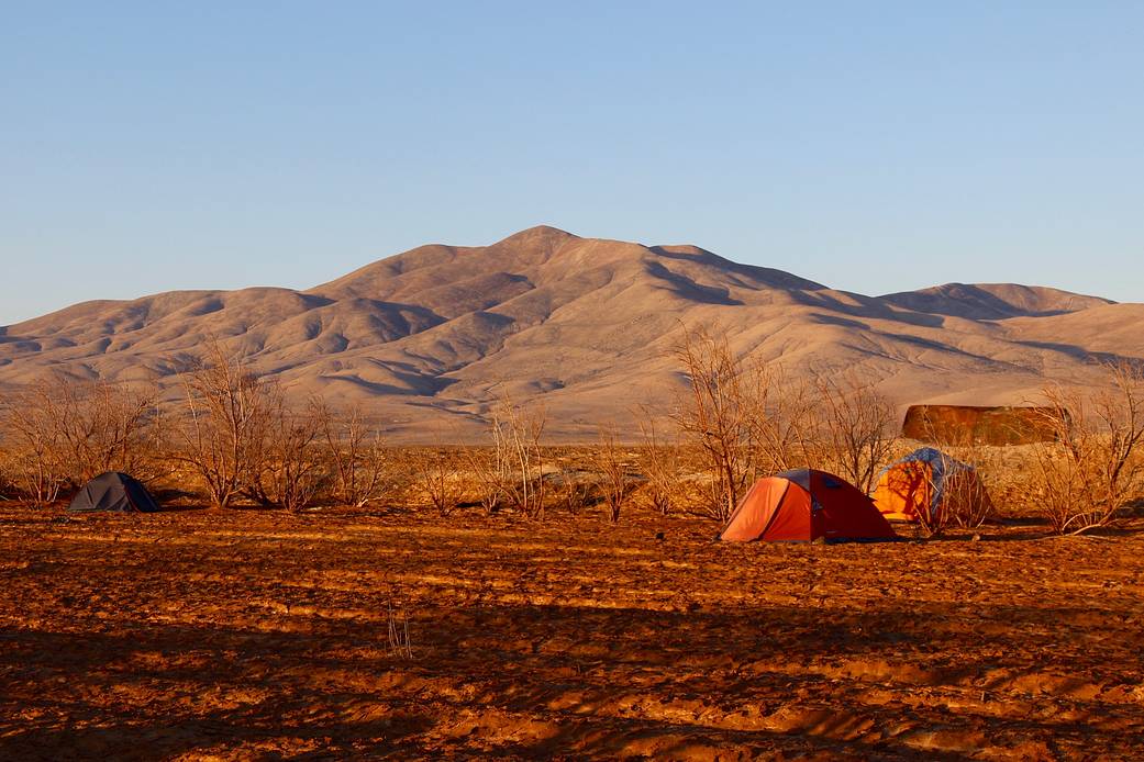 Tents are set up against a backdrop of hills iin the Atacama Desert.