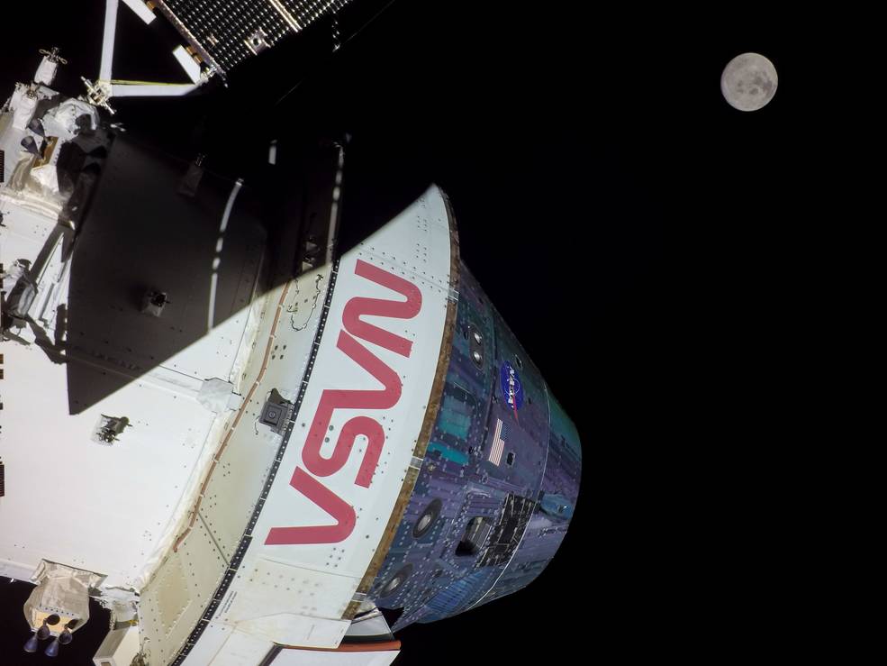 Artemis I approaching the Moon. NASA in red lettering along the side. 
