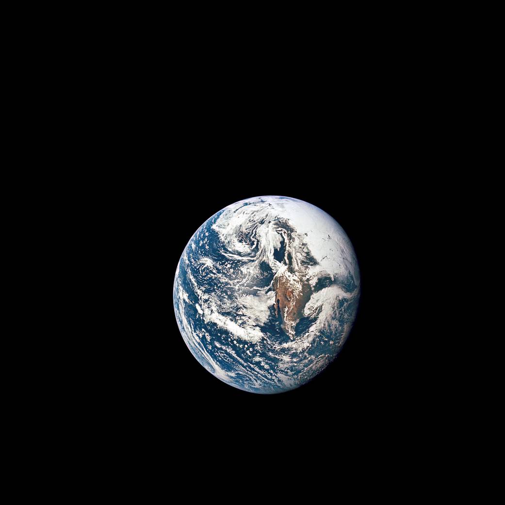Earth is seen from a distance in the blackness of space as photographed from Apollo 10 capsule