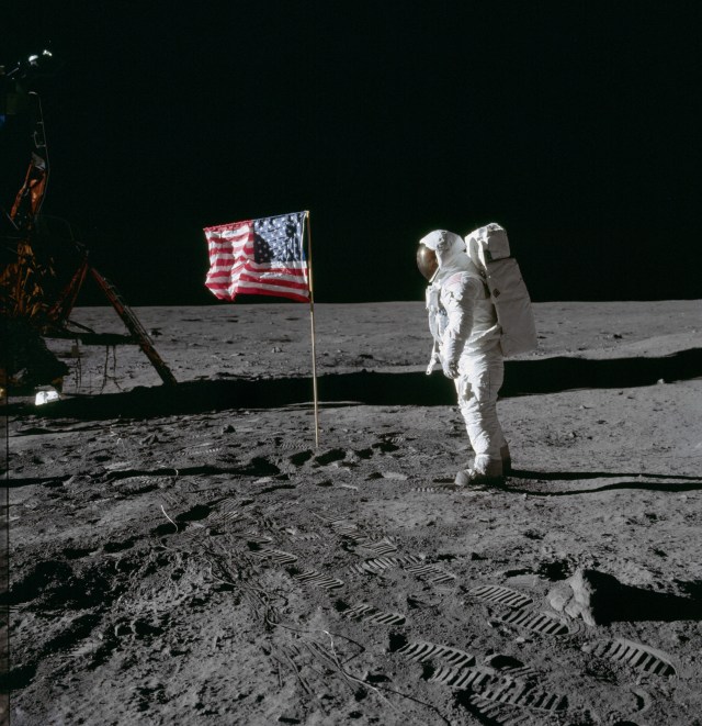 Astronaut Edwin Aldrin poses for photograph beside deployed U.S. flag