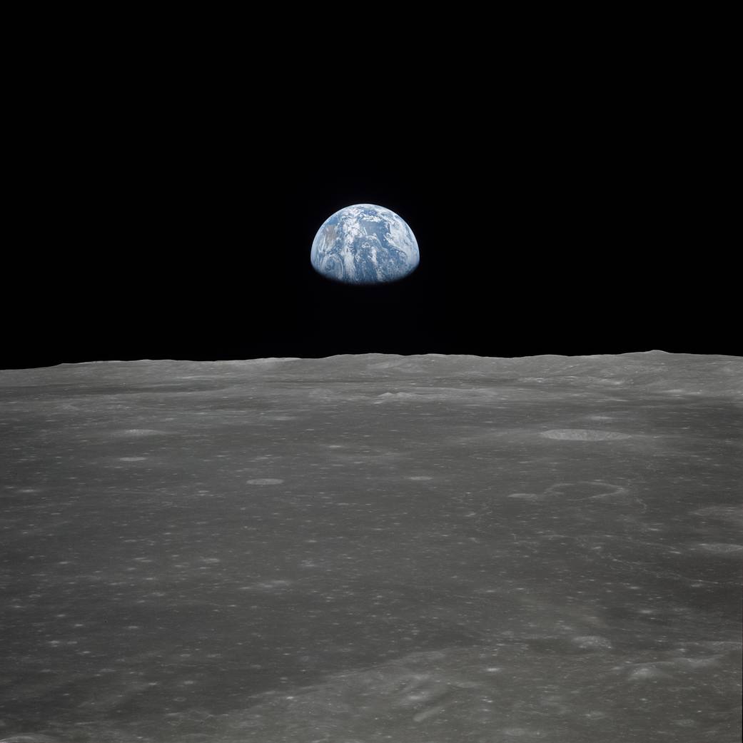 Earth rising over lunar horizon