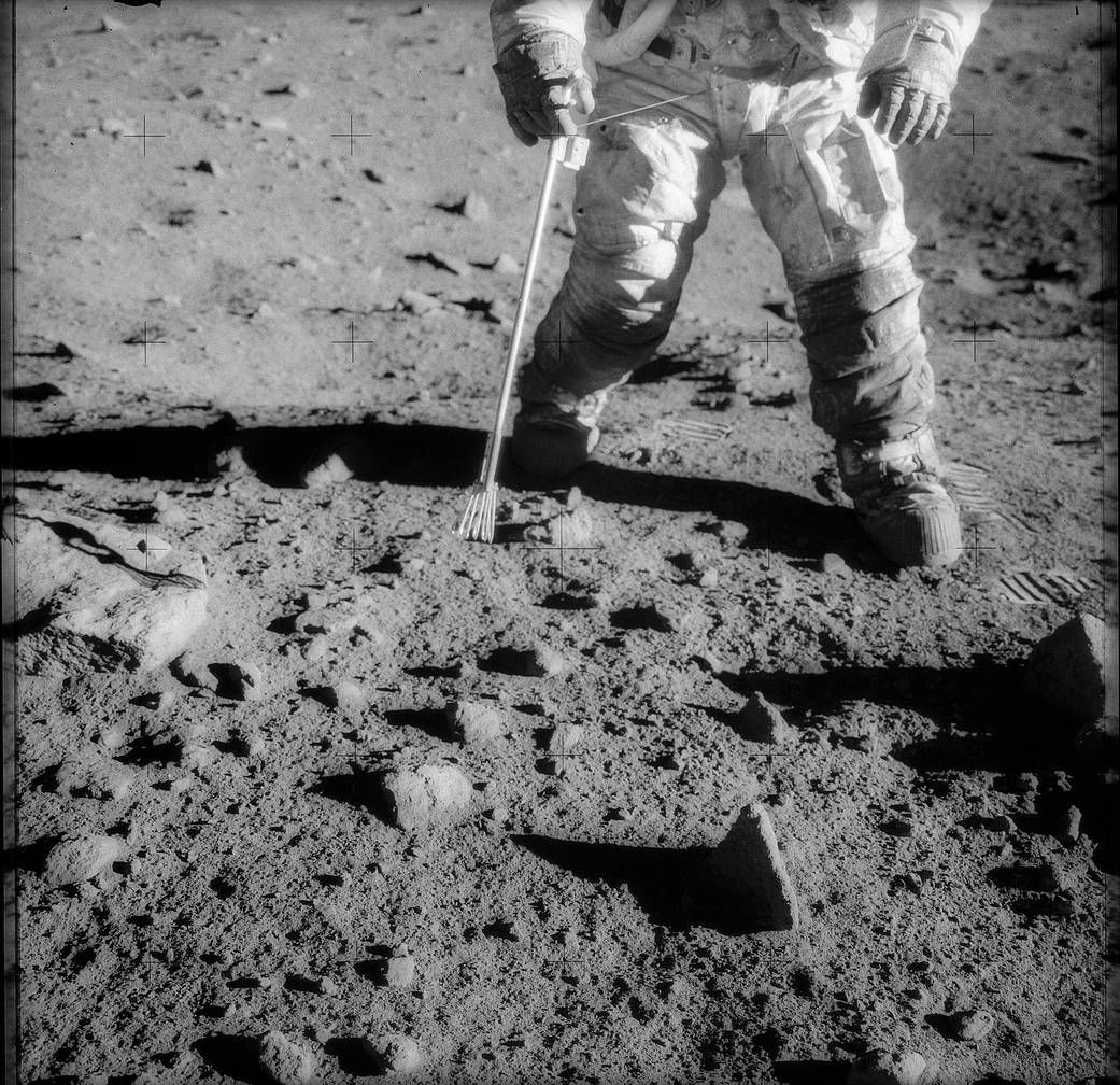 Closeup of astronaut's legs and feed in spacesuit during walk on lunar surface