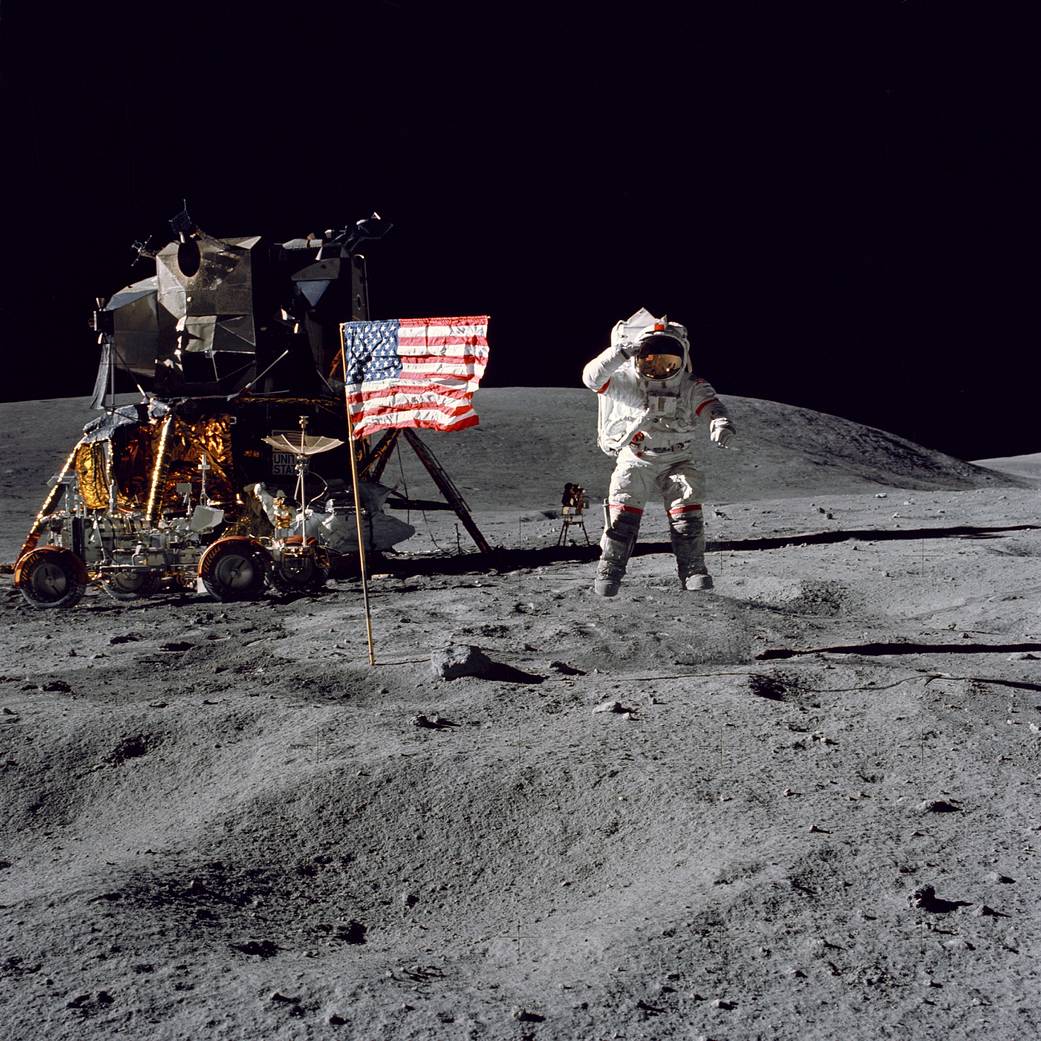 Astronaut John W. Young, commander of the Apollo 16 lunar landing mission, leaps from the lunar surface as he salutes the flag.