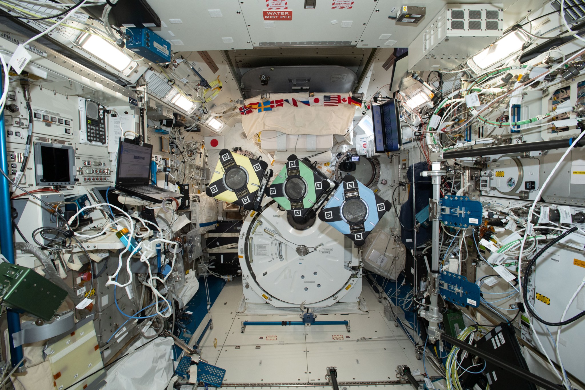 The space station’s free-flying Astrobees shown in this image support Zero Robotics, a program where students compete to write software to control one of the robots.