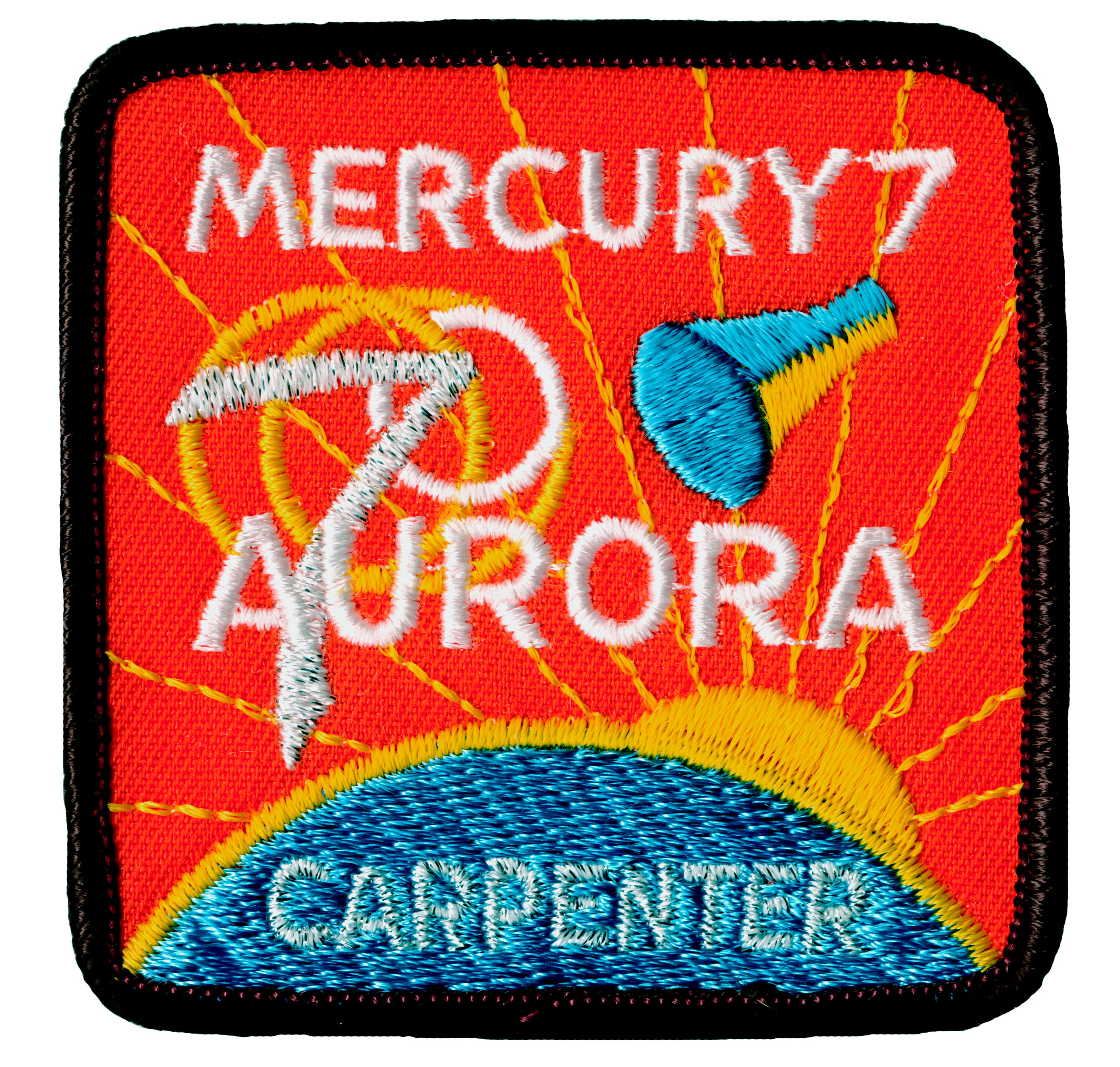 Mission patch for Mercury Atlas 7: Aurora 7 showing a Mercury capsule above the Earth with the sun peeking out behind the planet. Carpenter appears at the bottom of the patch.