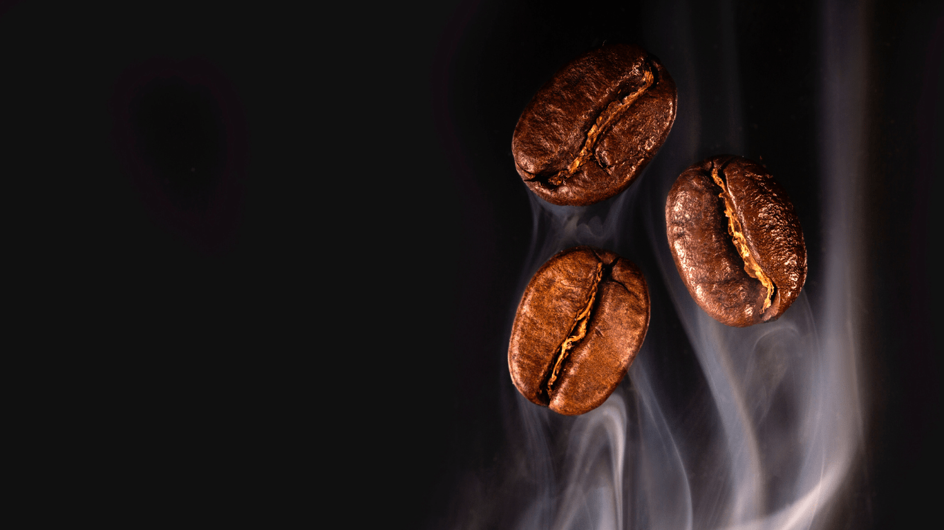three coffee beans on a black surface