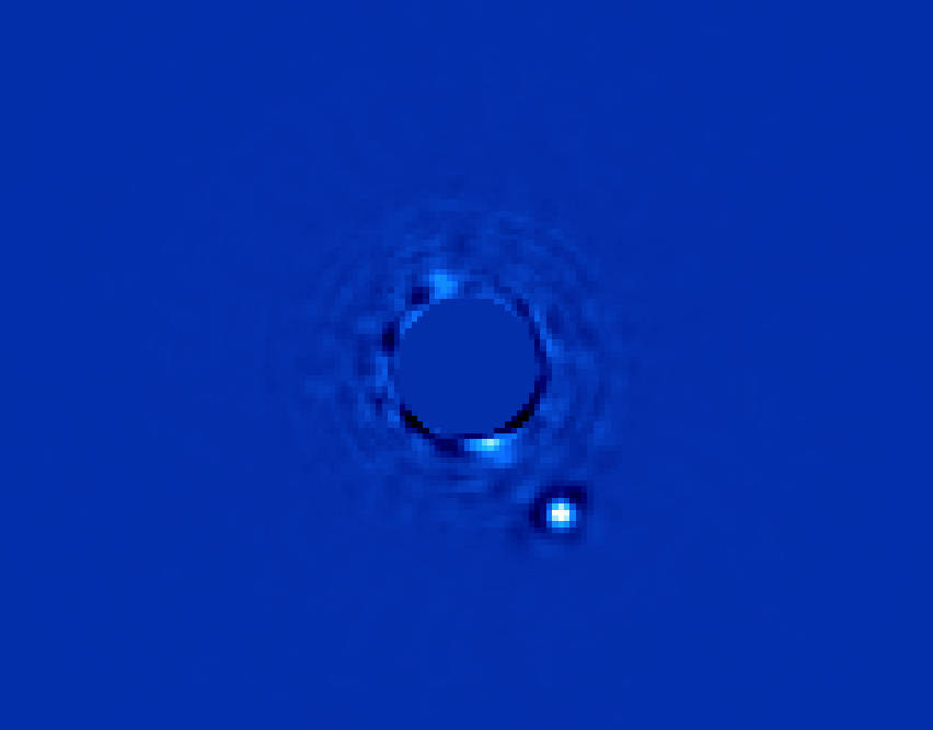 Field of blue with faint circular shape at center and small white burst of light in lower right