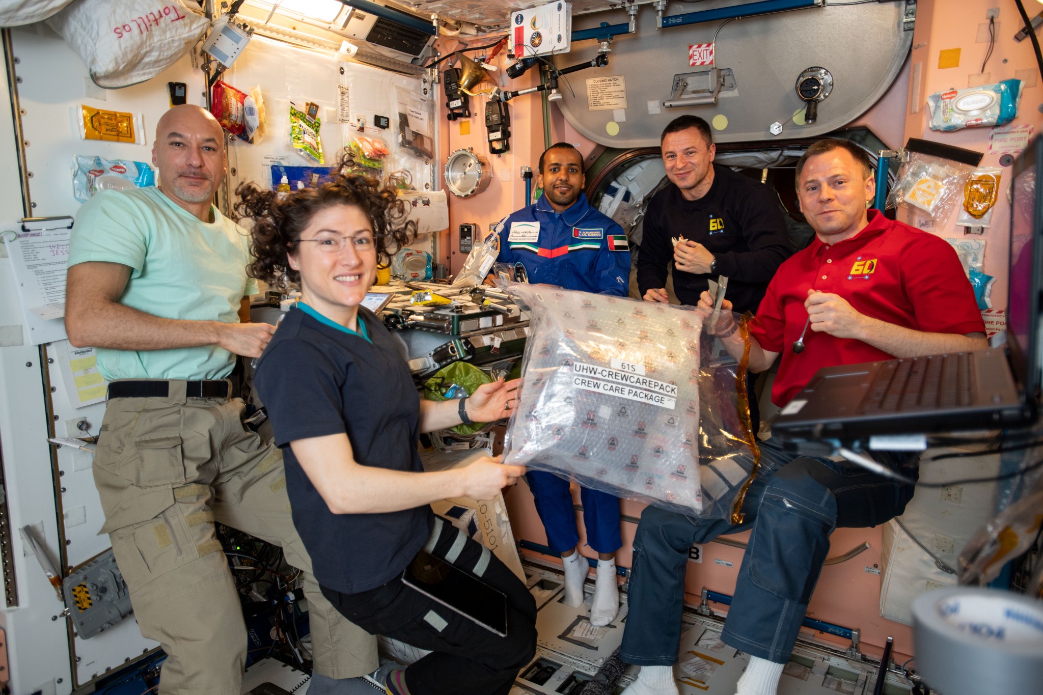 Astronauts aboard the ISS open a crew care package.