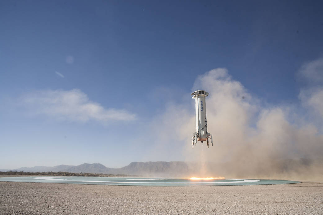 Blue Origin’s New Shepard booster rocket returns to its West Texas launch pad on Dec. 12
