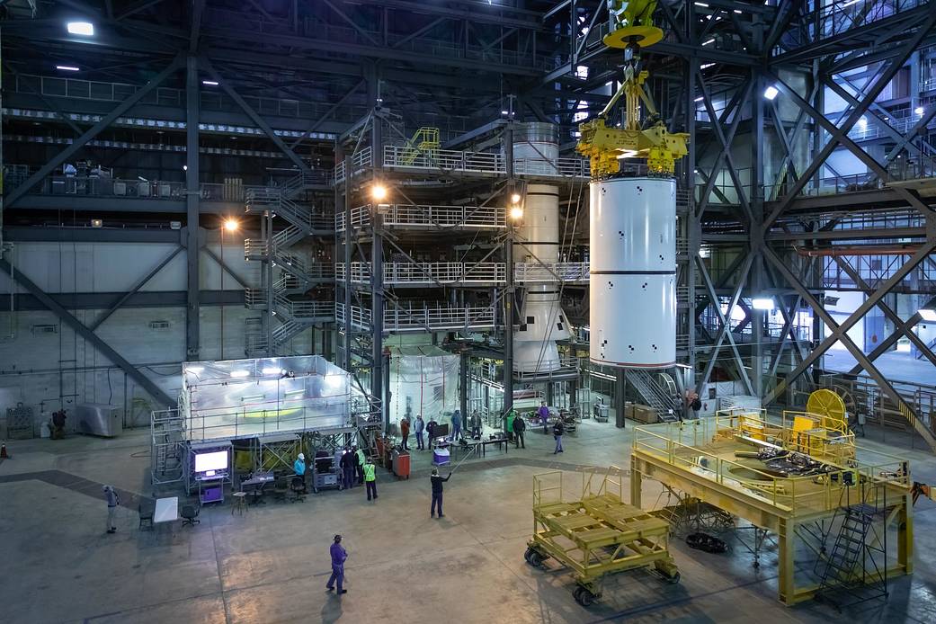 Teams practice lifting and stacking solid rocket booster segments for the Space Launch System in the Vehicle Assembly Building.