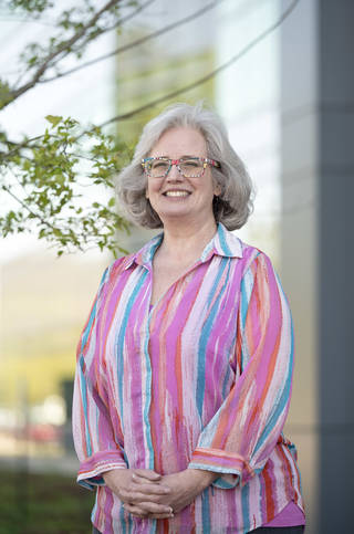 Becky Grimaldi, manager of the Exploration Projects and Integration Office at Marshall, stands outside in a pink shirt with multi-colored stripes.