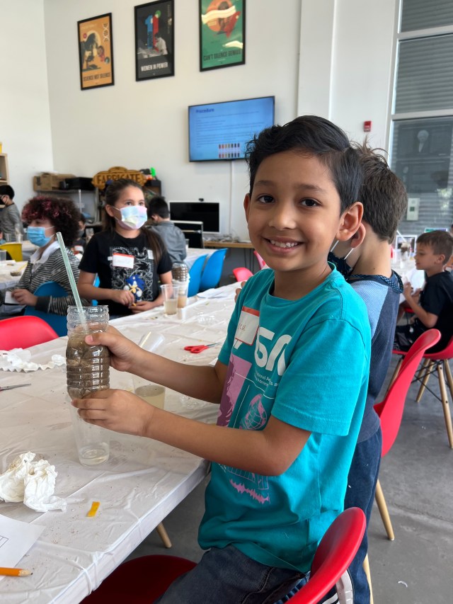 Lucca Soto works on his water filtration experiment using a variety of materials such as sand, rock, coffee filters, and more during a World Water Day event in March 2022 at Fab Lab El Paso