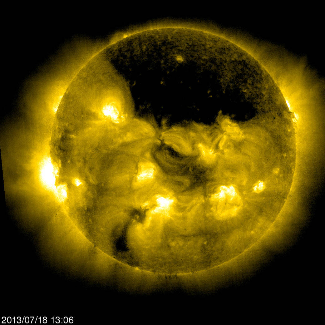 SOHO captured this image of a gigantic coronal hole hovering over the sun’s north pole on July 18, 2013.