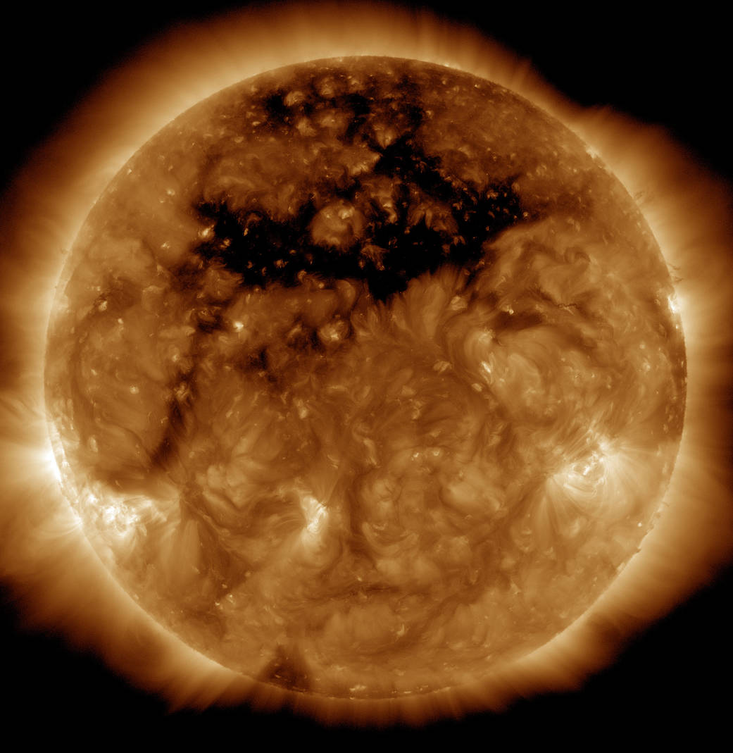 The dark area across the top of the sun is a coronal hole