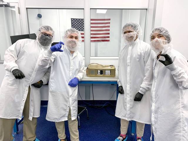 Four engineers from Terran Orbital Corporation pose with the CubeSat Proximity Operations and Demonstration (CPOD) spacecraft at their facility in California. 