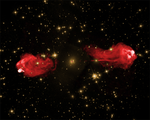 Two images of Cygnus A layered over each other to show the galaxy’s jets glowing in red and background stars in yellow.