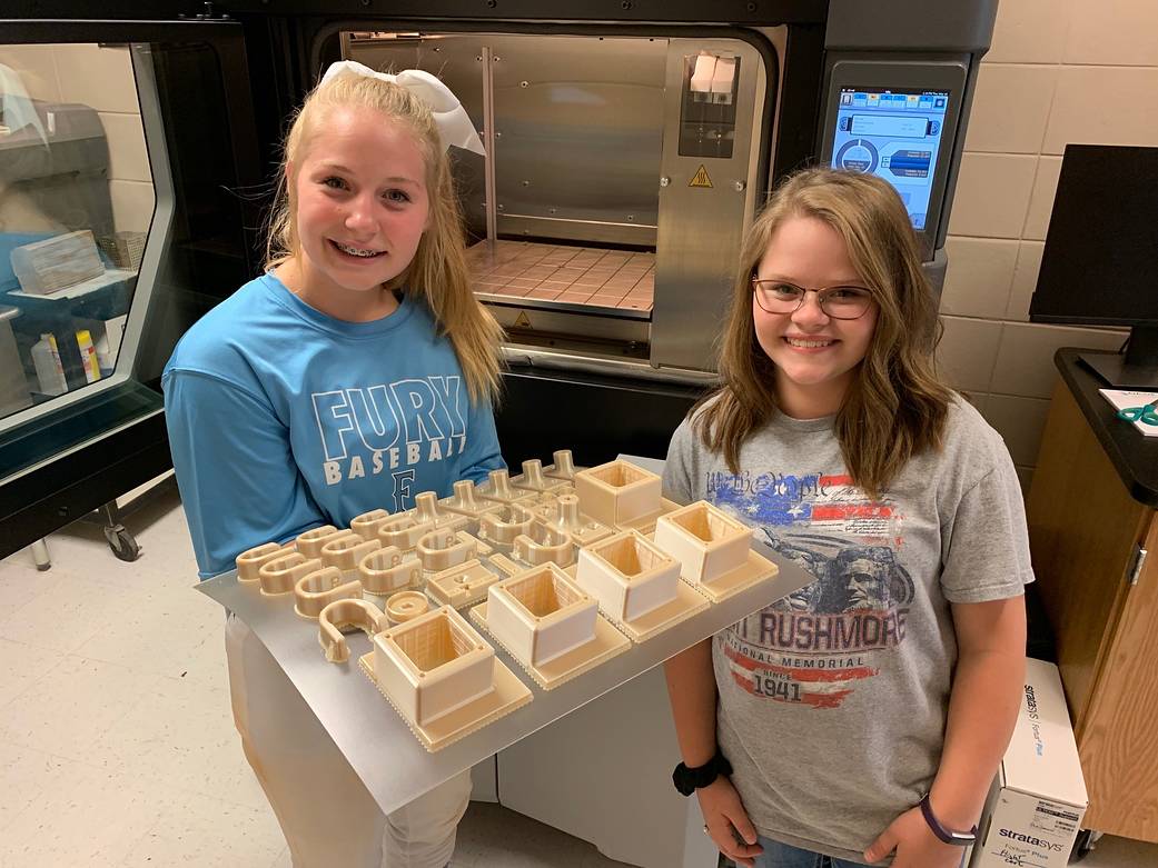 Dade County, Georgia, Middle School HUNCH students KK Castleberry, left, and Meleah Smith show 3D-printed items.