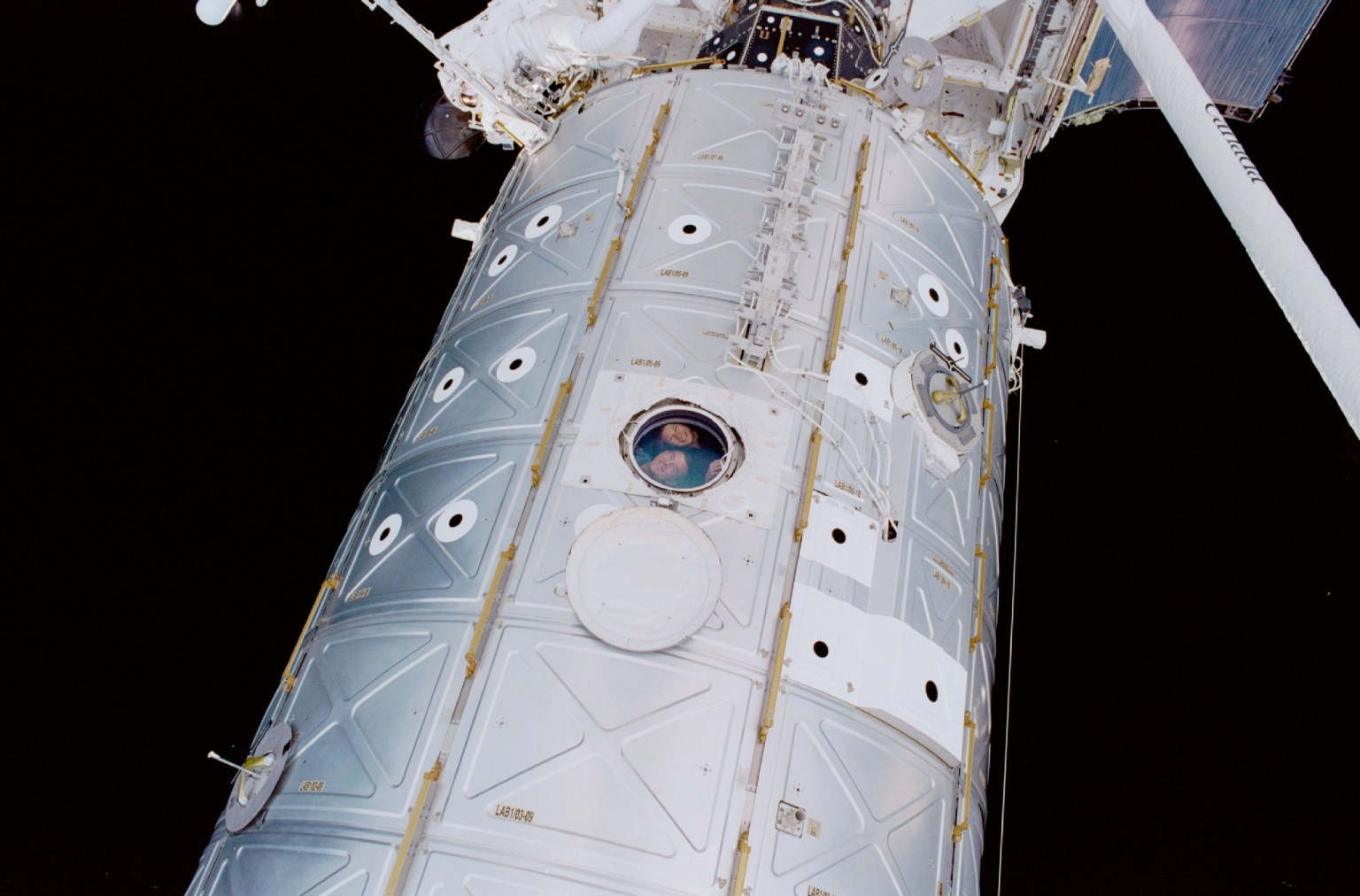 A close look at the window in this picture of the Destiny laboratory reveals the faces of astronauts Susan J. Helms and James S. Voss, flight engineers for the Expedition Two mission. One of the two STS-100 space walkers--astronauts Scott E. Parazynski and Chris A. Hadfield--exposed the image with a 35mm camera on one of two days of extravehicular activity (EVA) during the STS-100 mission.