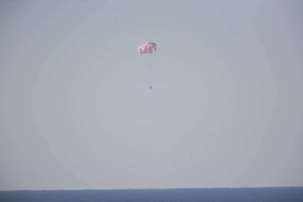 The SpaceX main parachutes control the descent of the Dragon test article following a test over the Pacific Ocean