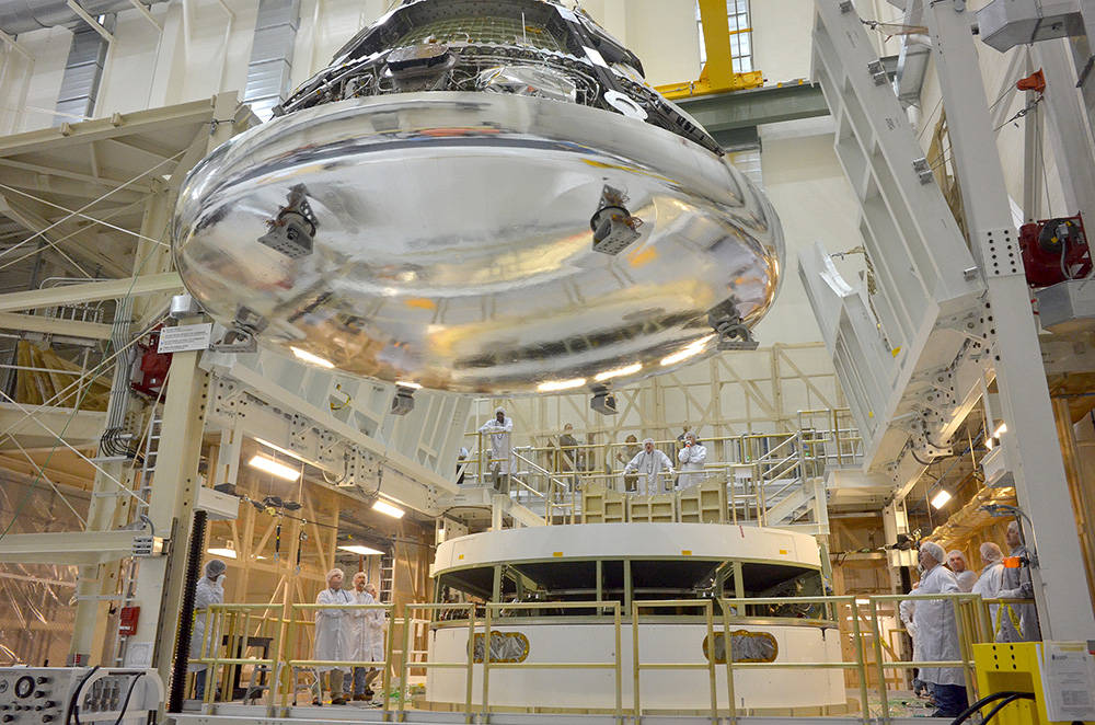 The Orion crew module for Exploration Flight Test-1 is shown in the Final Assembly and System Testing (FAST) Cell, positioned ov