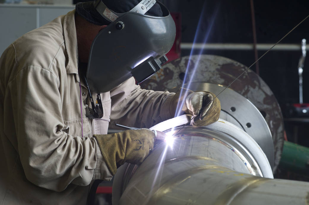A welder at  works on a portion of piping to be installed on the A-1 Test Stand for RS-25 rocket engine testing.