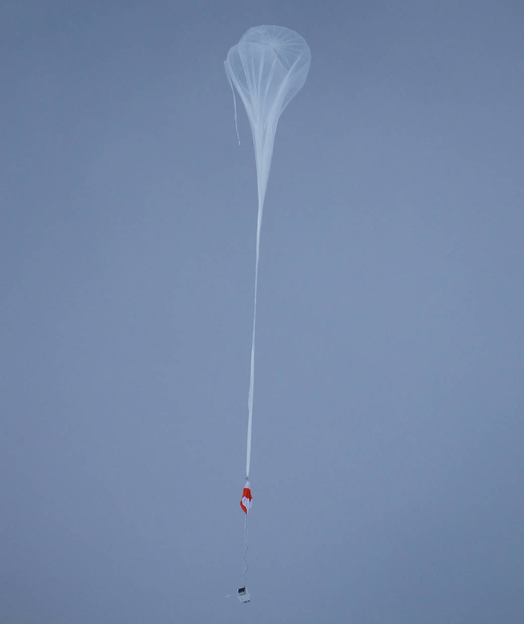A white balloon against a blue sky
