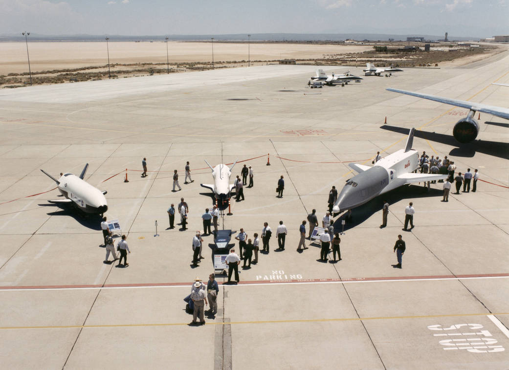 Aerospace industry representatives view actual and mock-up versions of 'X-Planes' during a technical exposition.